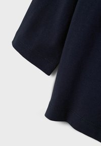 T-shirt in cotone blu navy con maniche corte, scollatura rotonda e tessuto liscio con dettagli di cucitura visibili lungo l'orlo.