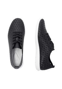 Black perforated sneakers with a hexagonal pattern, white rubber sole, and black laces, featuring a rounded toe and breathable design.
