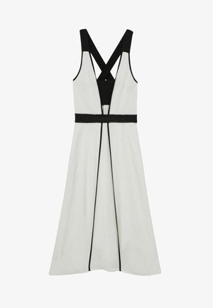 Balta suknelė su juodais akcentais, turinti prigludusią liemenę, kryžmines petnešas ir tekstūruotą juodą juostos diržą. Lygus audinys su aiškiomis linijomis.