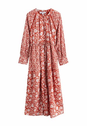 Long-sleeve midi dress with red background and white floral pattern, gathered waist with tie belt, and loose fit.