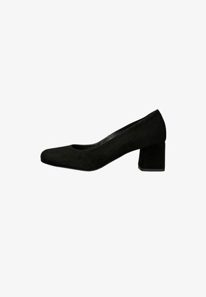 Zwarte suède dames schoen met lage blokhak en afgeronde neus, zijaanzicht op een witte achtergrond.