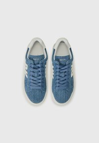 Blå denim sneakers med hvite gummisåler, med flate lisser og en subtil DKNY-logo. Jevn tekstur og avslappet design.