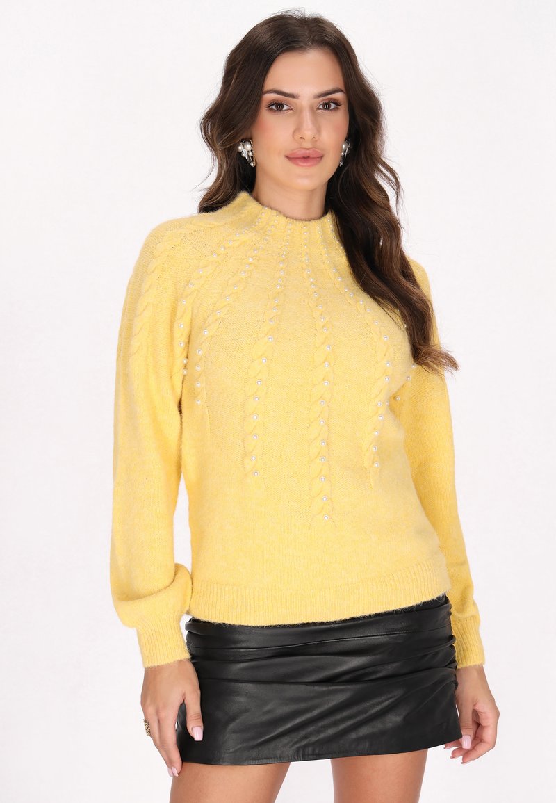 Gelbes Sweatshirt mit Kabelstrickmuster, akzentuiert durch perlenartige Beads. Verfügt über einen hohen Kragen und lange, leicht gepuffte Ärmel.