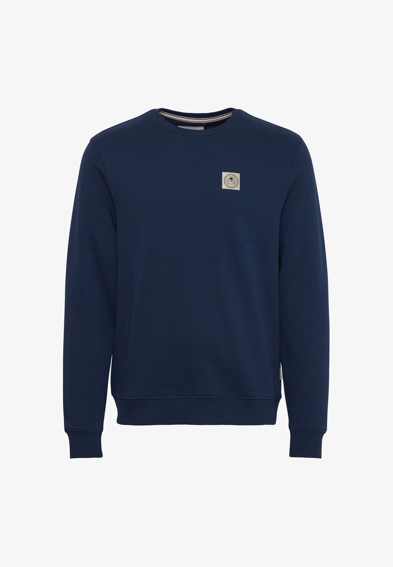 Sweat-shirt bleu marine à manches longues avec col rond, poignets et ourlet côtelés, et petit patch logo beige sur la poitrine gauche.