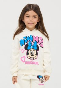 Felpa color crema con una grande grafica di Minnie Mouse, dotata di un fiocco blu e accenti rosa, abbinata a pantaloni e polsini coordinati.
