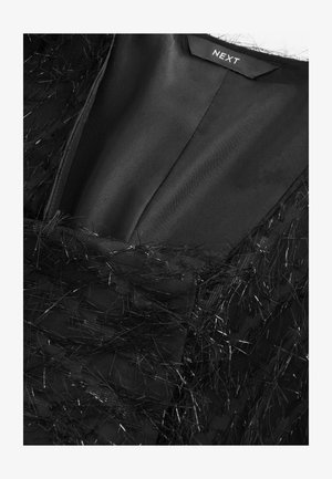 Rochie neagră cu un strat texturat ce prezintă fire metalice, decolteu adânc în V și căptușeală interioară netedă. Eticheta este inscripționată cu "NEXT".