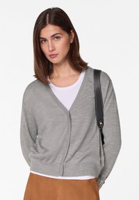 Grauer langärmeliger Cardigan mit V-Ausschnitt, aus weichem Strickmaterial. Verfügt über eine taillierte Passform und einen Reißverschluss vorne.