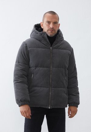 Sivi korduroi puffer jakna s kapuljačom, s zatvaračem na zip i rebrastim manžetama. Dva bočna džepa i mekana unutrašnja obloga.