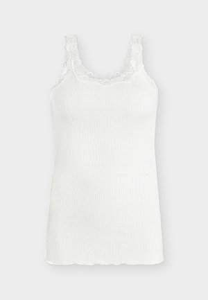 Hvit ribbestrikket ermeløs tanktopp med blonder rundt scoop-halsringning og stropper, vist på en enkel lys bakgrunn.