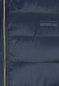 Dunkelblaue Pufferjacke mit Reißverschluss, gesteppten Abschnitten und einer glatten, glänzenden Textur mit minimalen reflektierenden Details.