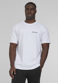 White cotton t-shirt with short sleeves, round neckline, and small black text "forgotten faces" printed on the left side.