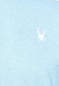 Light blue short-sleeve shirt with a textured grid pattern; features a white spider logo on the left chest.