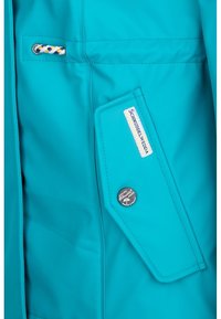 Turkusowa wodoodporna kurtka z materiału z kieszenią na naszywce, zapinaną na guzik i ozdobnym sznurkiem. Metka głosi "Schmuddelwedda."