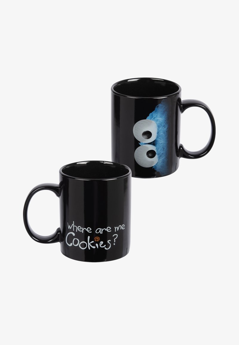 Mug in ceramica nera con testo bianco che recita "dove sono i miei biscotti?" e un design di personaggio blu con grandi occhi sul lato opposto.