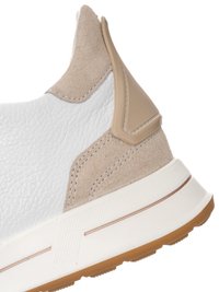 Primo piano del tallone di una sneaker beige e bianca con pelle testurizzata, pannelli in suede, suola in gomma e supporto del tallone sintetico color marrone chiaro.