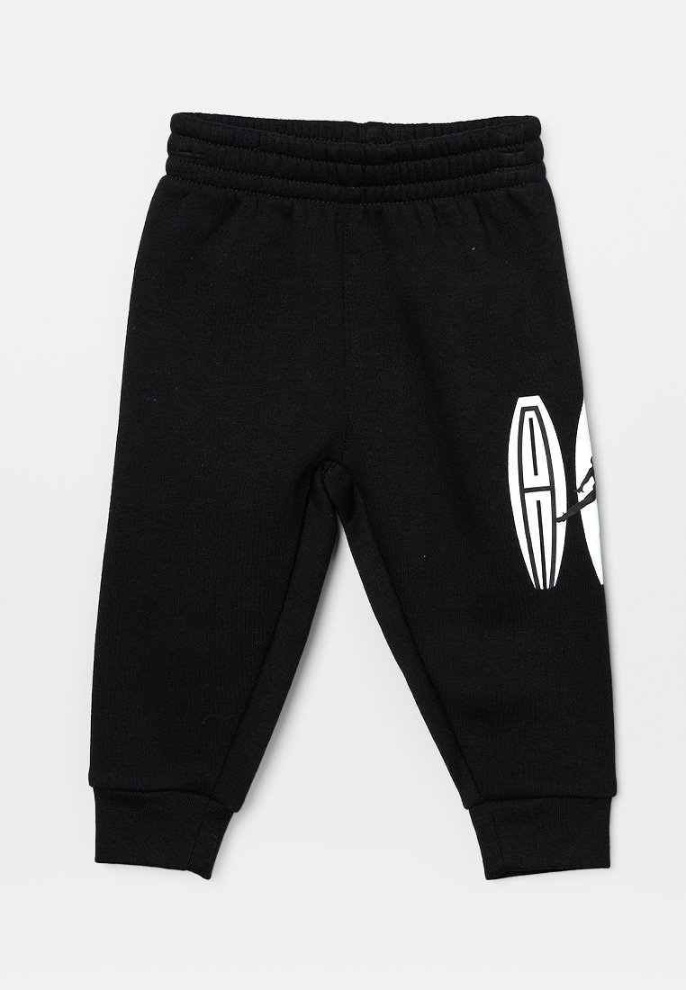Pantalones de chándal negros con una cinturilla elástica, puños ajustados y un diseño gráfico blanco en un lado, hechos de suave material de algodón.