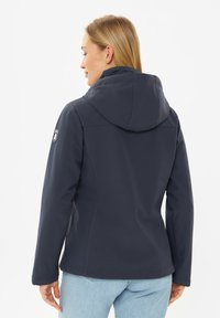 Navyblauwe, met capuchon, jas gemaakt van zacht, flexibel materiaal. Heeft een getailleerd ontwerp en een logopatch op de linkerschouder.