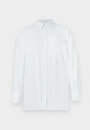 Chemise boutonnée bleu clair avec col, manches longues et poche poitrine. Le tissu semble lisse avec une subtile texture ; dispose de boutons jaunes.