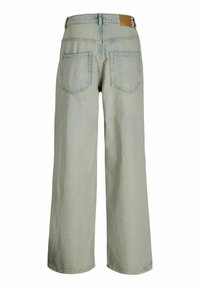 Široke traperke v svetlo modrem denimu z zbledelim zaključkom, ki imajo pet žepov in rjavo usnjeno oznako na pasu.