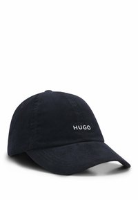 Mørkeblå kordfløjt baseballcap med buet skygge og hvid broderet "HUGO" logo på fronten. Teksturstof, justerbar rem bagpå.