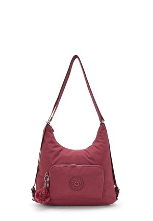 Red nylon shoulder bag with curved shape, exterior zip pocket, and logo patch. Includes a furry monkey charm as an accent detail.