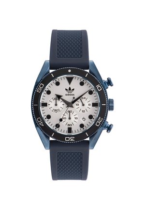 Montre chronographe bleue avec un cadran argenté, des index noirs et un bracelet en caoutchouc texturé bleu. Comprend trois sous-cadrans et une lunette rotative.