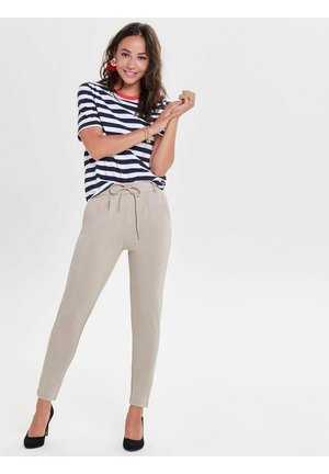 Striped navy and white short-sleeve shirt with red trim paired with beige tapered pants, featuring a drawstring waist and black heels.