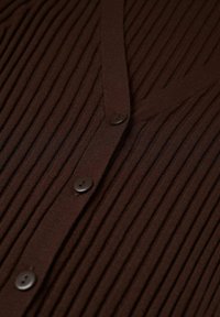 Brown ribbed cardigan with a V-neckline, featuring five black buttons along the front. Made of textured knit fabric.