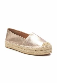 Espadrilles metálicas en color rosa dorado con suela de cuerda de yute, punta redondeada y acento tejido en la parte delantera. Textura suave, diseño sin cordones.