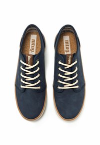 Scarpe in tela blu navy con lacci beige, sole in sughero e suole in gomma. Texture liscia, design semplice e branding minimale.