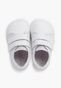 Scarpe bianche in pelle con doppia fibbia a velcro, punta arrotondata e soletta testurizzata. Presentano il marchio "Blanditos by Cris" all'interno.