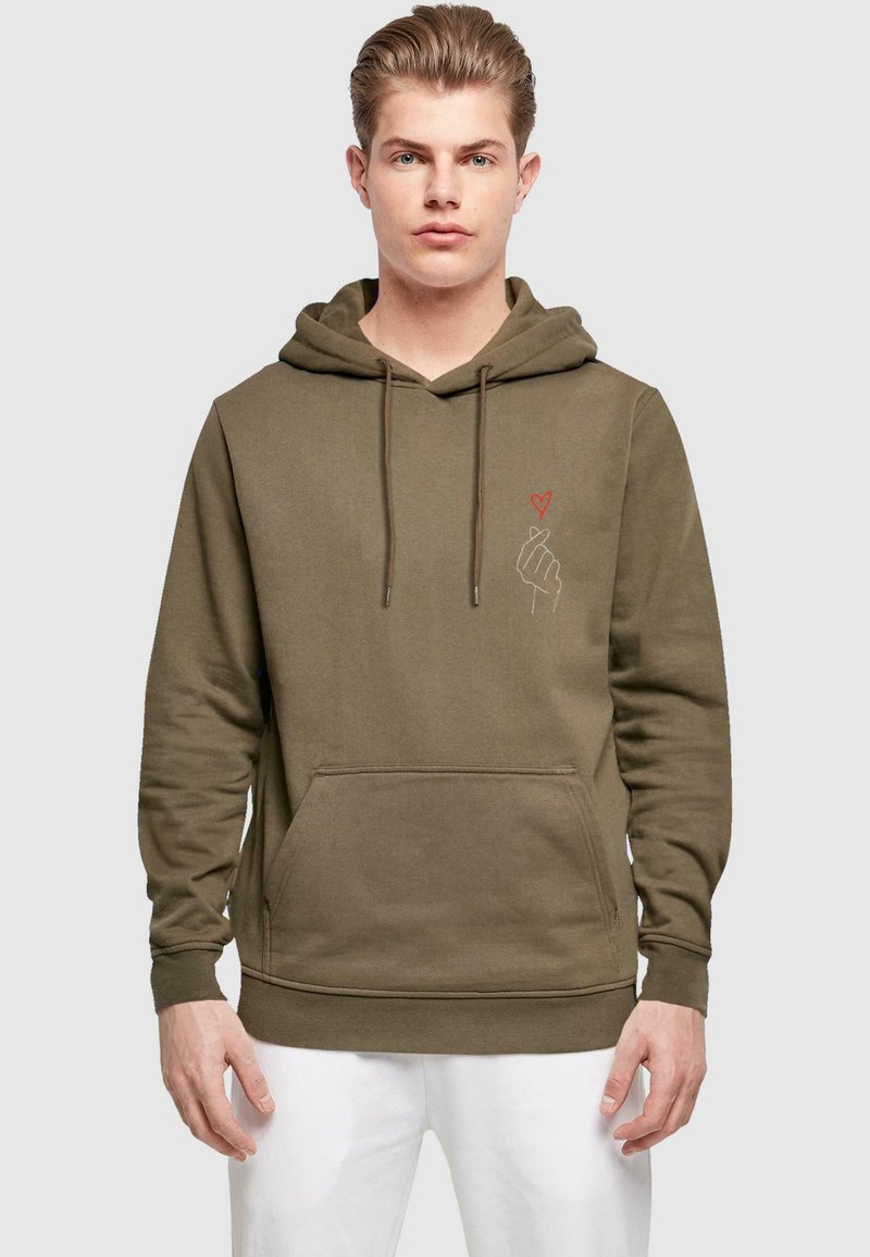 Felpa verde oliva in misto cotone con tasca a marsupio. Presenta una grafica rossa a forma di cuore e mano sul lato sinistro del petto. Cappuccio con coulisse regolabile.