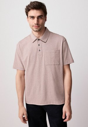 Khaki polo tričko s krátkým rukávem z měkké, texturované látky, s knoflíkovou légou a kapsou na prsou. Podrobný prošívání zvýrazňuje design.