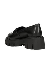 Scarpa in pelle nera con suola spessa e testurizzata e punta arrotondata. Presenta un dettaglio decorativo a fibbia sulla parte superiore.
