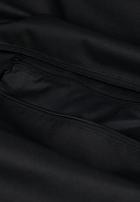 Schwarzes Stoffinterieur mit mehreren Reißverschlussfächern, ausgestattet mit einer glatten Textur und robusten Nähten für verbesserte Haltbarkeit.