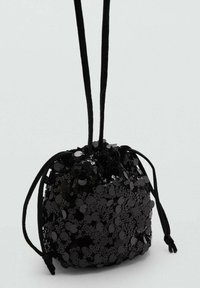 Černý taška na stažení se znamením, měkkou texturou a dlouhými černými popruhy. Bezešvé uzavření s nařaseným detailem na vrchu.