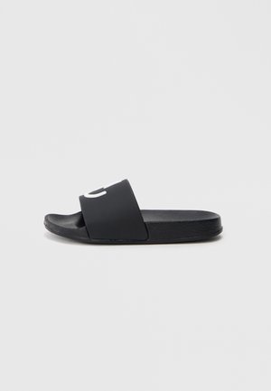 Black slide sandal with a textured rubber sole and a wide band featuring contrasting white lettering across the top. Simple design, open-toe.