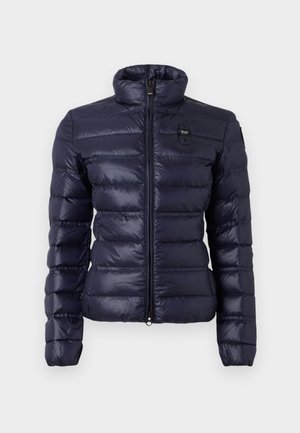 Marineblauwe pufferjack met een hoge kraag, horizontaal gestikte ontwerp, ritssluiting aan de voorkant en logo-opdruk op de borst. Zacht, glanzend materiaal.