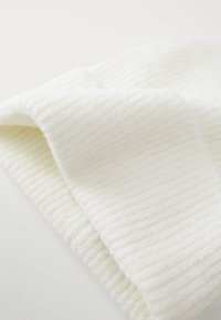 Geribde witte sjaal gemaakt van zacht materiaal, met een textuurdesign en lichte pluizigheid voor warmte en comfort.
