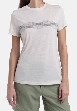 Un t-shirt beige clair à manches courtes, avec une texture douce, présentant un motif de lignes ondulées gris foncé sur la poitrine. À associer avec un pantalon vert.