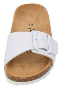 Witte slide sandaal met een brede band en een verstelbare gesp. Kurk voetbed met een getailleerde vorm. Rubberen zool voor grip en duurzaamheid.