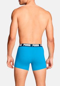 Blauer Trunk-Stil Unterwäsche aus Stretchstoff, mit einem schwarzen Bund und „PUMA“-Logo, glatter Textur und figurbetontem Design.