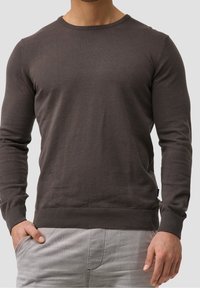 Dark gray long-sleeve sweater in a soft knit fabric. Features a round neckline, ribbed cuffs, and hem, with a relaxed fit.