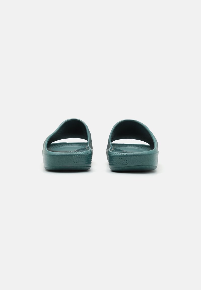 Sandales en caoutchouc teal avec un dos ouvert et des brides larges. Semelle intérieure texturée et détails à motifs sur les côtés pour une adhérence améliorée.