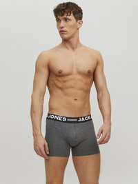 Graue Boxershorts aus einem weichen Stoff mit einem schwarzen elastischen Bund, der mit dem weißen Text "JACK & JONES" verziert ist. Enganliegendes Design und glatte Textur.