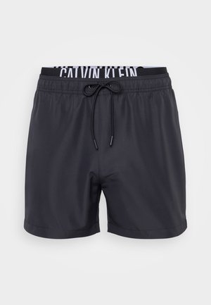 Crne kupaće hlače od glatkog materijala, sa elastičnim pojasom i bijelim "Calvin Klein" logotipom, uz zatvaranje sa vezicom.