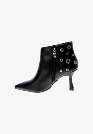 Stivale alla caviglia in pelle nera con punta appuntita, zip laterale e dettagli circolari in argento su un lato. Presenta un tacco a stiletto.