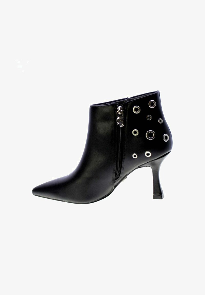 Stivale alla caviglia in pelle nera con punta appuntita, zip laterale e dettagli circolari in argento su un lato. Presenta un tacco a stiletto.