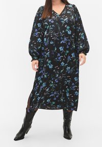 Black floral dress featuring a V-neck, long puff sleeves, and side slits. Accented with blue and green patterned flowers on soft fabric.