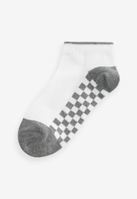 Vit ankelsocka med grå tå och häl. Grå rutmönster längs sidan. Mjuk tyg med ribbat mudd vid öppningen.